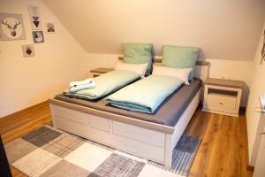 een bed met twee kussens erop in een kamer bij Wohnung Pinot in Seenähe in Friedrichshafen