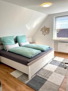 een slaapkamer met een bed met blauwe kussens erop bij Wohnung Pinot in Seenähe in Friedrichshafen