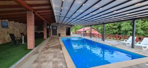 a swimming pool with a pergola on a house at Vila Breza in Laktaši