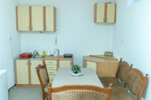 a kitchen with a table and chairs and a kitchen with a sink at Smještaj Biker in Trebinje