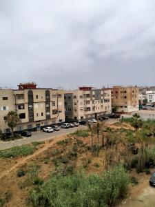 an apartment complex with cars parked in a parking lot at Superbe appartement proche de toutes les commodités Salé in Sale