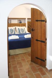 a bedroom with a bed and an open door at Casa do Limoeiro - sleeps up to 4 comfortably in Serpa