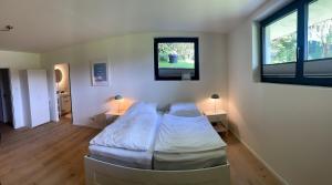 a bedroom with two beds and two windows at Sailors Retreat in Strande