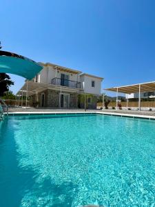 a swimming pool in front of a house at Çam Tatil Evleri in Datca