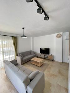 a living room with a couch and a tv at Çam Tatil Evleri in Datca +17 photos