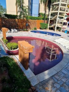 a person jumping into a swimming pool in a yard at Golden Dolphin Express Caldas Novas 309 in Caldas Novas