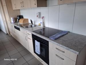 a kitchen with a sink and a stove top oven at Zimmer perla in Chur