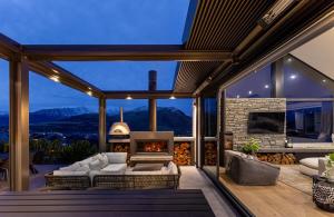 a living room with a fireplace in a house at Luxury Architectural Home with Pool, Spa and Sauna in Queenstown Airport