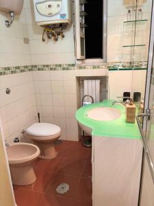 a bathroom with a green sink and a toilet at ADAapartmenthousesalerno in Salerno