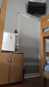 a room with a dresser and a tv on a wall at Recanto da Matriz - Águas da Prata in Águas da Prata
