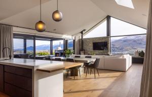 a kitchen and living room with views of mountains at Luxury Architectural Home with Pool, Spa and Sauna in Queenstown Airport
