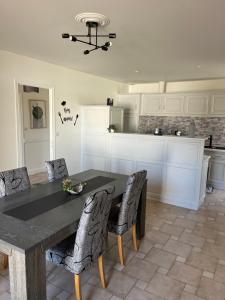 a kitchen with a table and chairs in a room at Les Murmures du Thouet in Thénezay