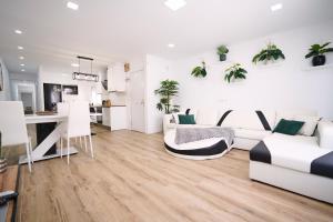 ベニカルロにあるNew Big City Center Apartment 4th floor no elevatorの白い家具と植物が壁に飾られたリビングルーム +11枚の写真