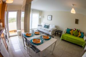 een woonkamer met een tafel en een groene bank bij Apartments Baleal: Close to the Sea + Pool in Baleal