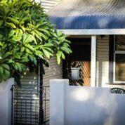 uma casa com duas palmeiras em frente em Heather's Mica Cottage em Broken Hill