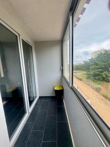 a room with a window and a bench in it at Mauves et Marées plage à 300m in Saint-Hilaire-de-Riez