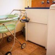 a kitchen with a cart next to a refrigerator at Heather's Mica Cottage in Broken Hill