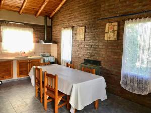 a kitchen with a white table and chairs in a room at Cabañas del Volga in El Hoyo +22 photos