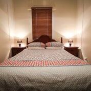 a bedroom with a large bed with two night stands at Heather's Mica Cottage in Broken Hill