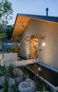 a house with a pond in front of a building at Sou in Isahaya