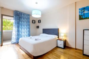 a bedroom with a large white bed and a window at Luminoso piso en La Laguna by CABANA Rentals in La Laguna