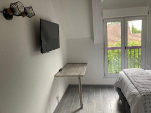 a room with a television on a wall with a bed at HSH France Chambre City 3 Proche de Disney in Meaux