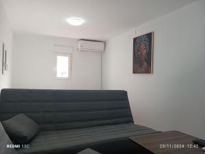 a living room with a couch and a picture on the wall at La posada del Mozarabe in Alquife