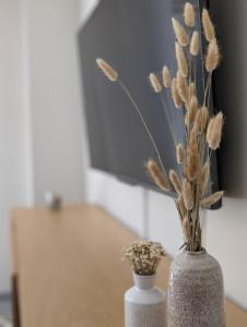 un vase avec des fleurs dedans sur une table dans l'établissement Le cottage du moulin - NETFLIX - WiFi - Garage, à Oresmaux 11 autres photos