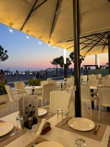 a restaurant with tables and chairs with a view of the ocean at DIELL HOTEL in Durrës