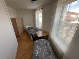 a room with two beds and a table and a window at Mama Zimmer in Tresdorf
