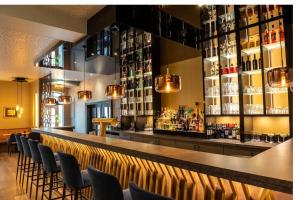 un bar con un montón de botellas de alcohol en Stadthotel Dinklage, Self-Check In, Restaurant am Hotel, en Dinklage