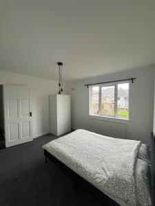 a white bedroom with a bed and a window at Villa nxt Rock, Cashel & palace in Cashel