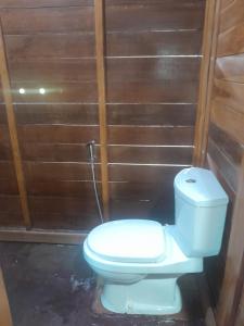 a bathroom with a toilet and a wooden wall at 361 Alam in Tetebatu +85 photos