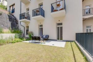 un patio di un appartamento con una sedia e l'erba di Visit Oomph Apartments a Praga