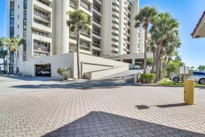 a large building with palm trees in a parking lot at Walk to Beach and Eats Condo with Pool in Clearwater! in Clearwater Beach
