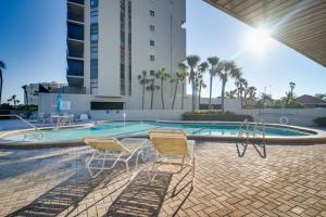 two chairs and a swimming pool in a building at Walk to Beach and Eats Condo with Pool in Clearwater! in Clearwater Beach