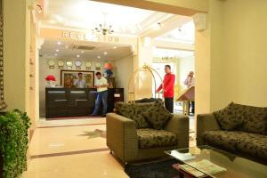 um lobby com duas pessoas em pé em uma loja em Pearl City Hotel em Colombo