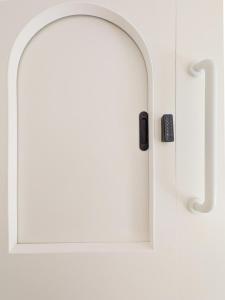 a white door with a window and a remote control at Brimfield Stay in Los Angeles
