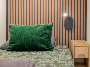 a green pillow sitting on top of a bed at Brimfield Stay in Los Angeles