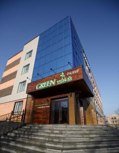 un edificio con escaleras delante de una ventana verde en GREEN Which Hotel en Petropavlovsk
