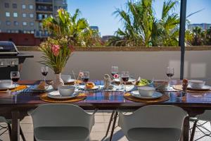 a wooden table with wine glasses and food on it at Knightsbridge Terrace in Cape Town +32 photos