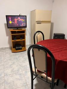 Zimmer mit einem Tisch und einem TV sowie einem Tisch und Stühlen in der Unterkunft Departamento nuevo con estacionamiento y patio privado in Palmira + 17 Fotos