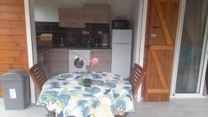 a table with a vase with a flower on it at Bwa Ka - Havre de paix et cosy in Saint-François