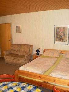 - une chambre avec 2 lits jumeaux et une chaise dans l'établissement Ferienwohnung In Gästehaus Mit Fahrradverleih, à Goosefeld