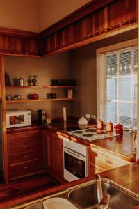 a kitchen with wooden cabinets and a stove top oven at Beachfront Villa, Spacious, Mountain Outlook - KK87184 in Kaikoura