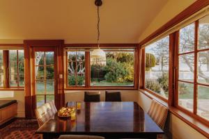 a dining room with a table and large windows at Beachfront Villa in Kaikoura