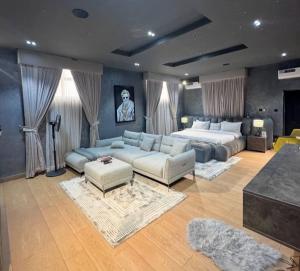 uma grande sala de estar com uma cama e um sofá em Maison Étoile em Kubwa
