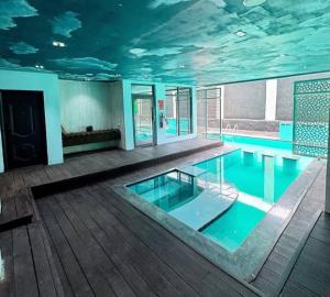 uma grande piscina com teto coberto de nuvens em Maison Étoile em Kubwa