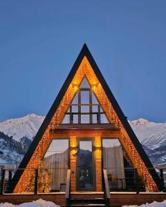 a house with lights on it in the snow at B&B Cottage in Mestia in Mestia