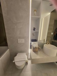 a white bathroom with a toilet and a sink at Happy Studio Cortina de Luxe in Voluntari